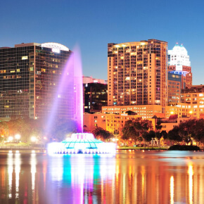 Miami waterfront at night with palm trees, yachts, and illuminated hotels