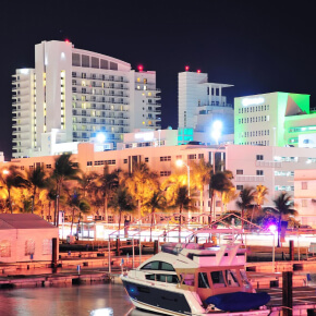 Orlando skyline at sunset with Lake Eola fountain lit in colorful lights